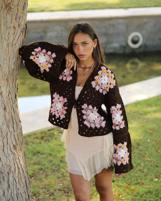 Woman wearing a floral crochet cardigan in an outdoor setting